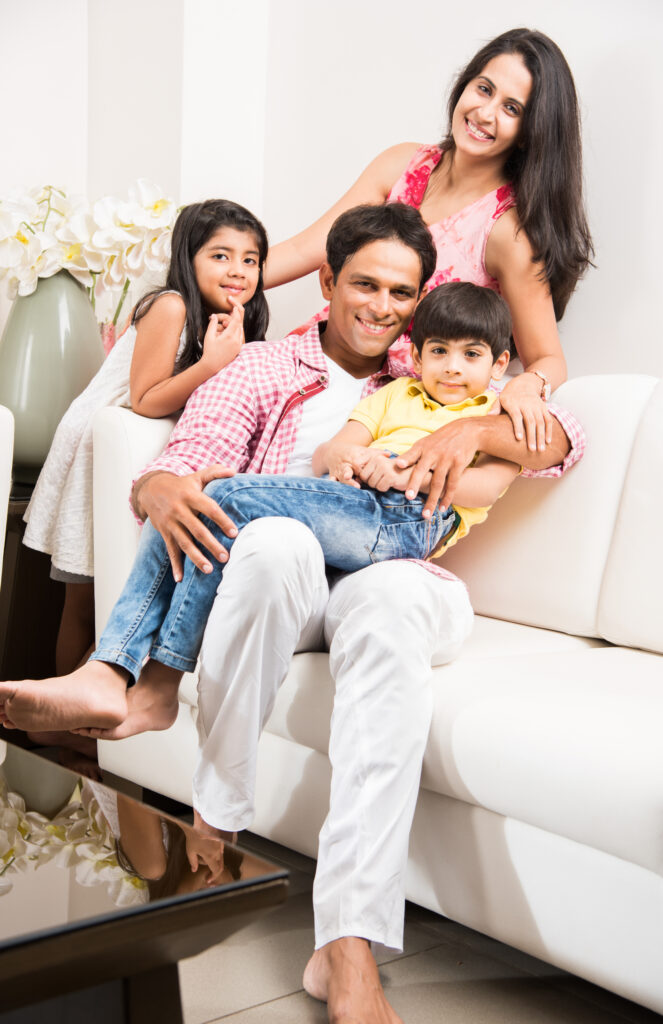 portrait of indian asian happy and young family, sitting over sofa at home