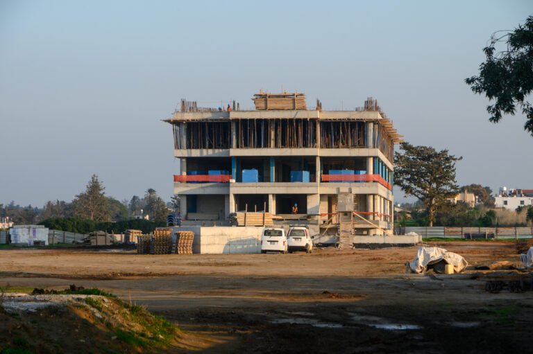 Construction of a modern building in a growing urban area during the afternoon